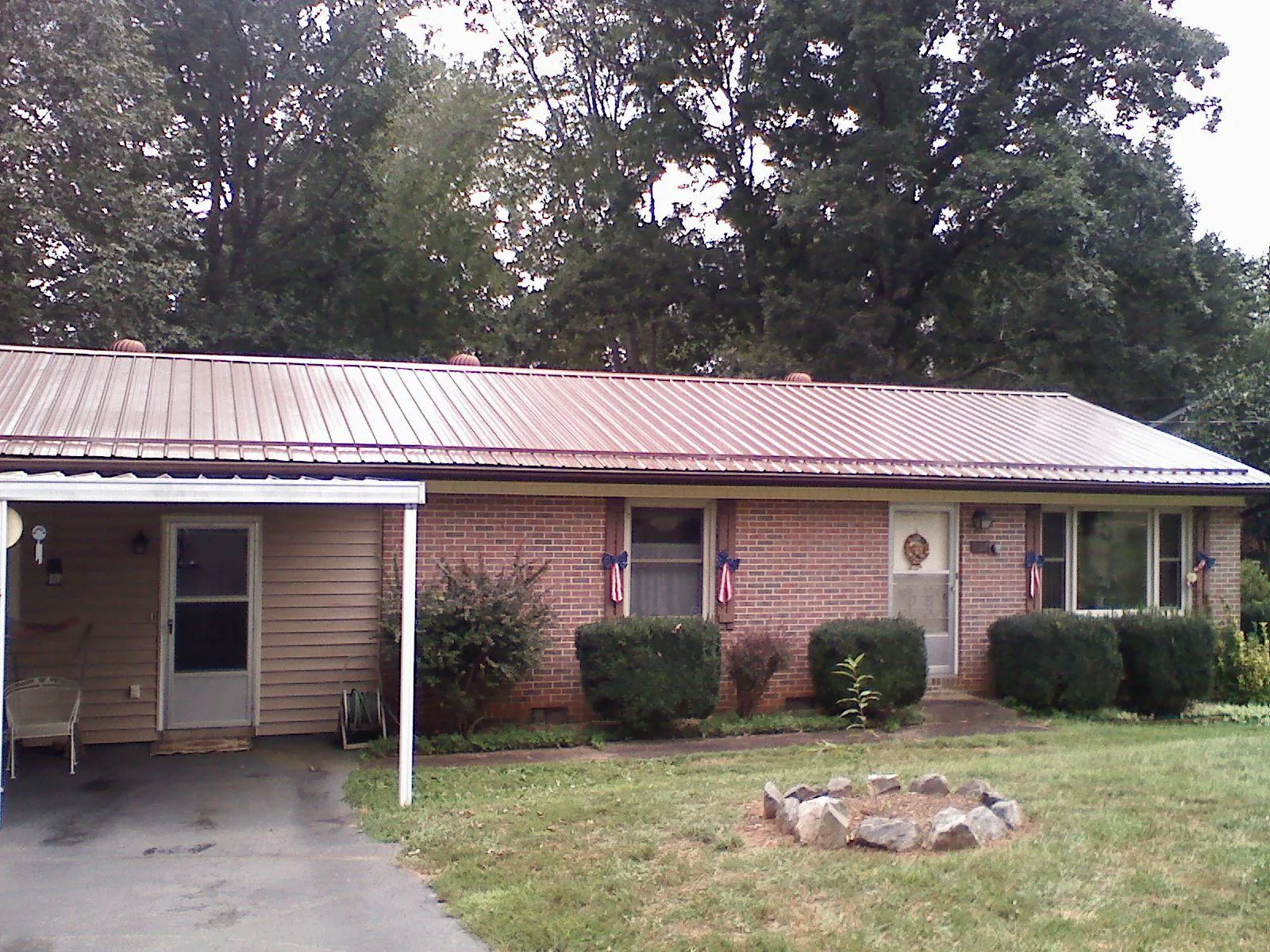 Bronze metal roof and carport on a brick ranch home — Roof Repair work by our crew in Homerville